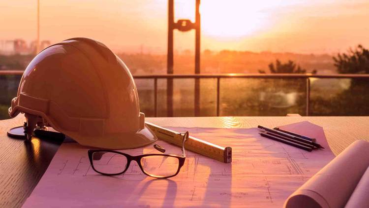 Helmet and blueprints at construction site
